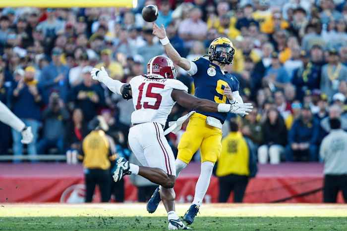 Michigan quarterback J.J. McCarthy passes under pressure from Alabama linebacker Dallas Turner. 